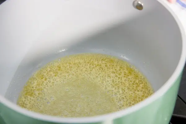 Butter wird in der Soßenpfanne des Caraway Antihaft-Keramik-Kochgeschirr-Sets gekocht