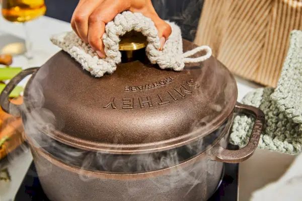 Eine Person öffnet den 5,5-Quart-Dutch-Ofen von Smithey Ironware