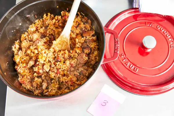 Eine Person kocht Hühnchen in der gusseisernen runden 5,5-Quart-Cocotte von Staub