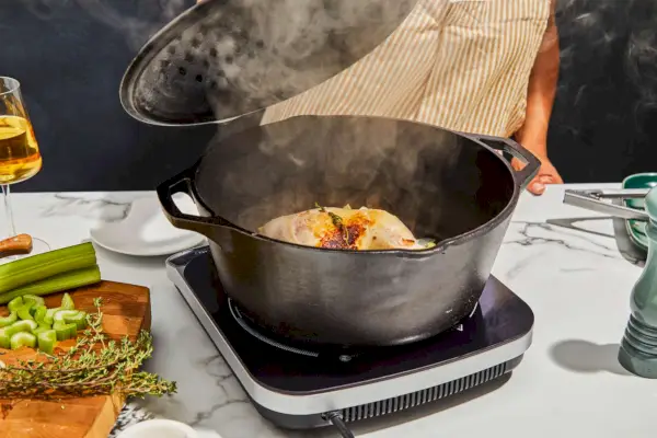 Eine Person öffnet den Lodge 5-Quart Cast Iron Double Dutch Oven