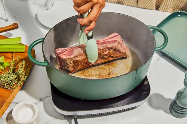 Eine Person, die Fleisch in Great Jones anbraten