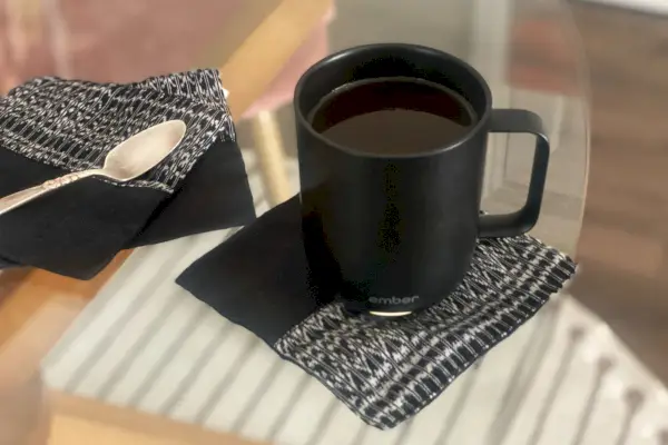 Čierny hrnček Ember Smart Mug 2 je umiestnený na sklenenej doske.